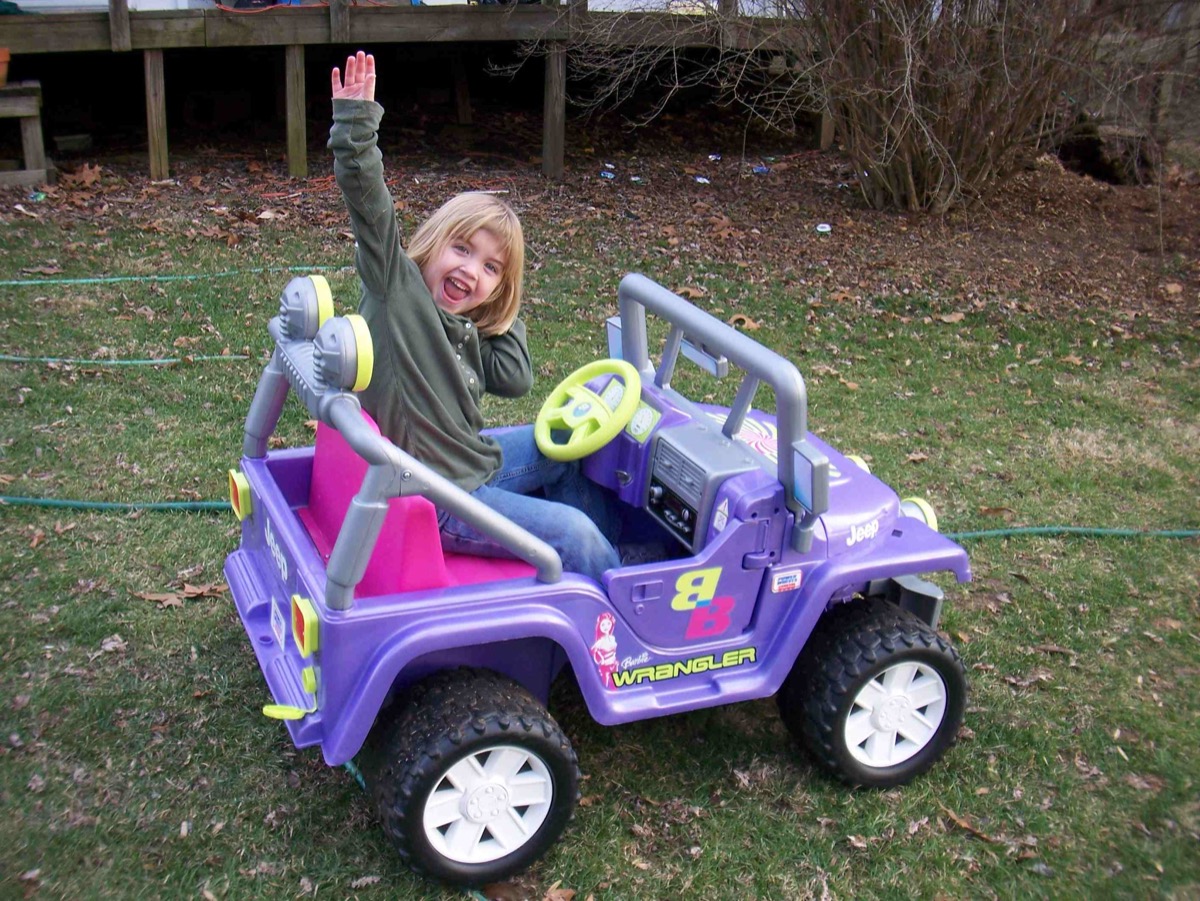little girl driving a barbie jeep