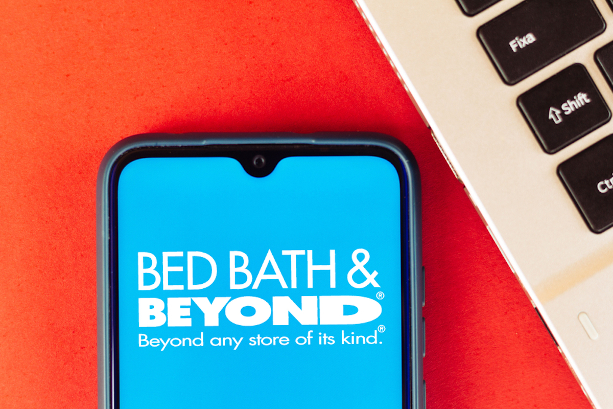 bed bath and beyond website shown on closeup of smart phone screen, blue background with white font