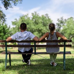 Couple sitting together on a bench in the park