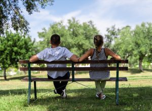 Couple sitting together on a bench in the park