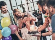 group of friends surprises a woman with a birthday cake