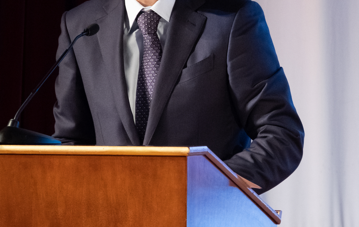 closeup of man's suit standing in front of podium