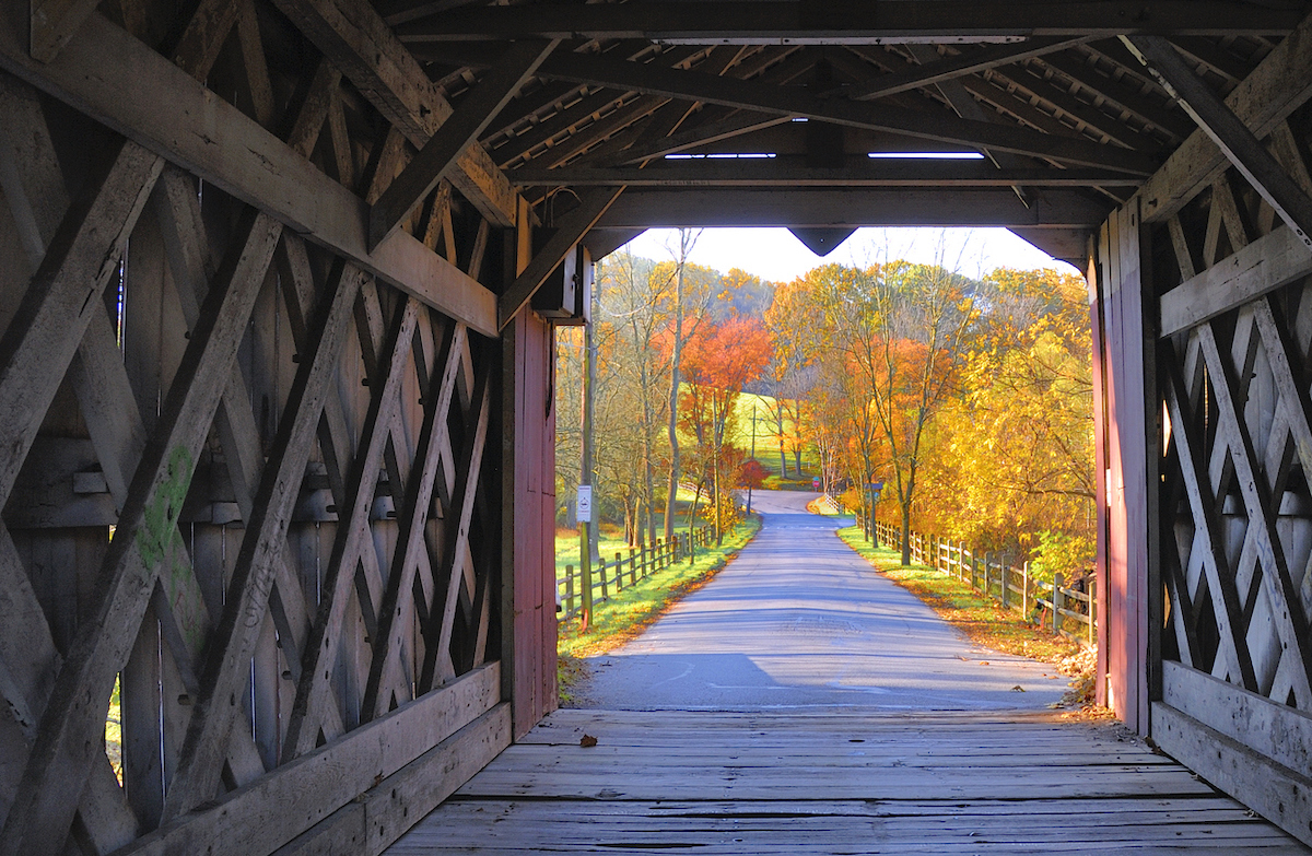 View from inside the Ashland covered bridge in Yorklyn, New Castle County, Delaware during the fall with colorful foliage in bright sunlight