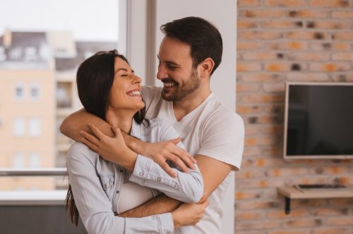 Couple sharing an embrace at home together