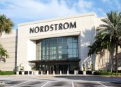 The exterior of a Nordstrom store whose entrance is flanked by palm trees