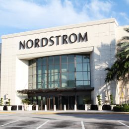 The exterior of a Nordstrom store whose entrance is flanked by palm trees