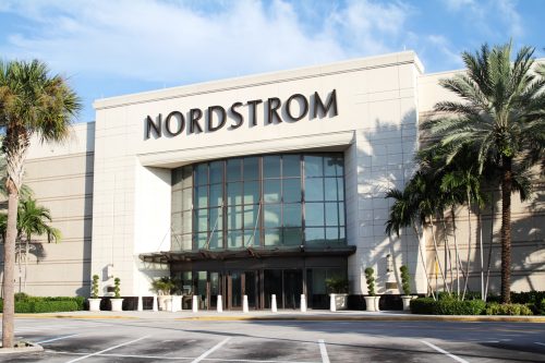 The exterior of a Nordstrom store whose entrance is flanked by palm trees