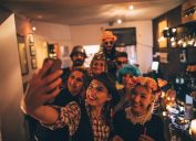 Group of costumed people having fun and making selfies on Halloween party