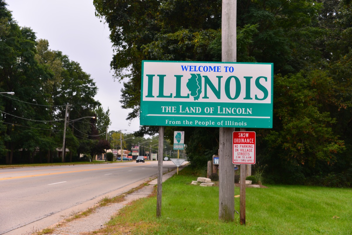a green "Welcome to Illinois" sign on the side of a road