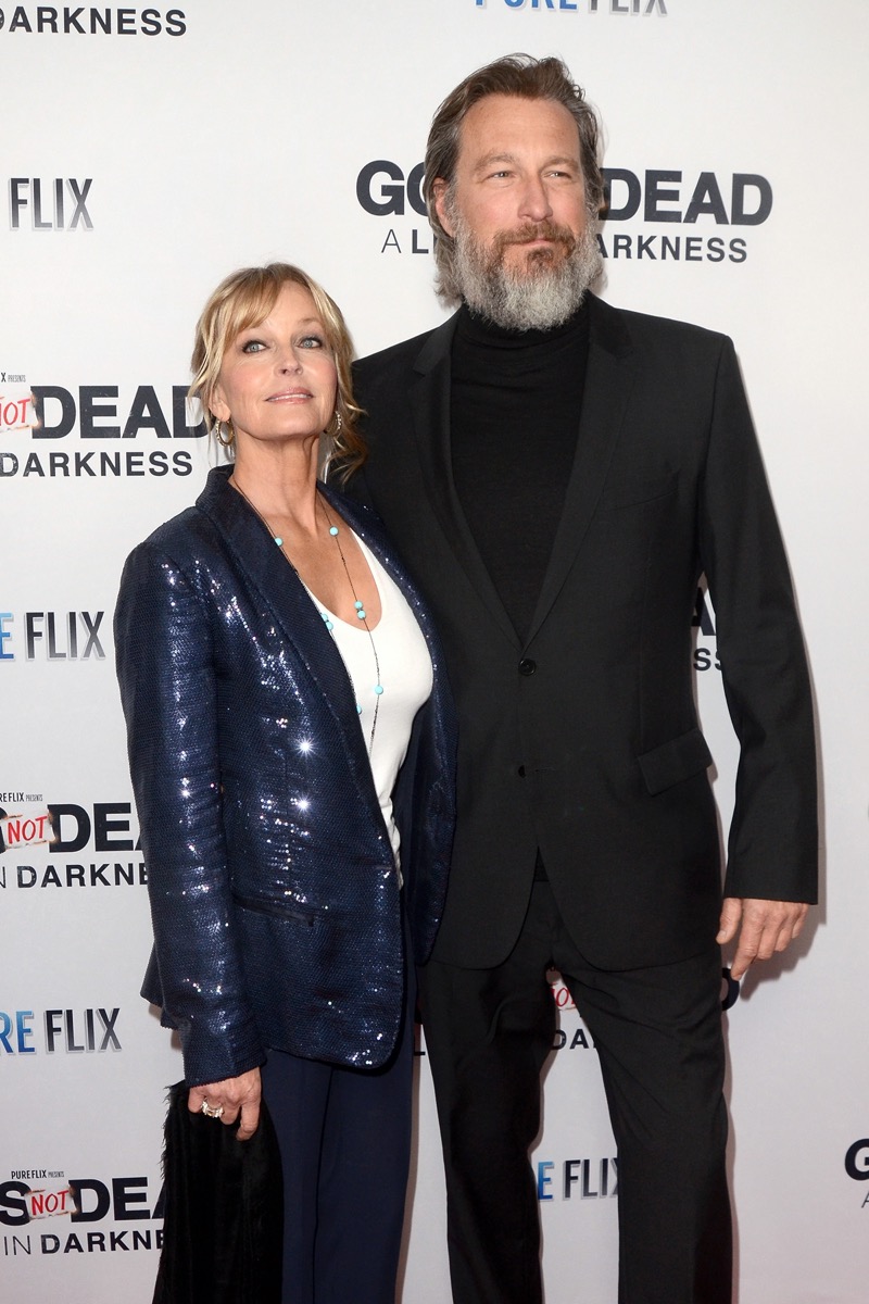 John Corbett wears black suit and Bo Derek wears a blue suit at the premiere of 'God's Not Dead: A Light in Darkness' in 2014
