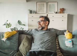 Men resting after cleaning kitchen during pandemic period. He finding way to make isolation period more active