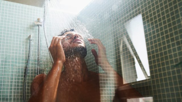 Cropped shot of a man having a refreshing shower at home