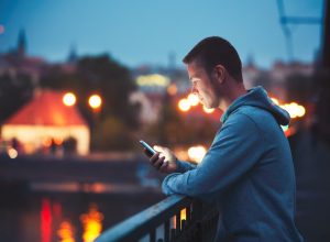 Man texting on balcony to cancel a date