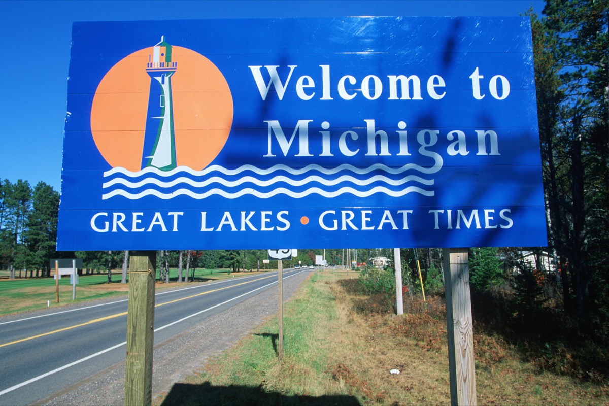 a blue "Welcome to Michigan" sign off of a highway