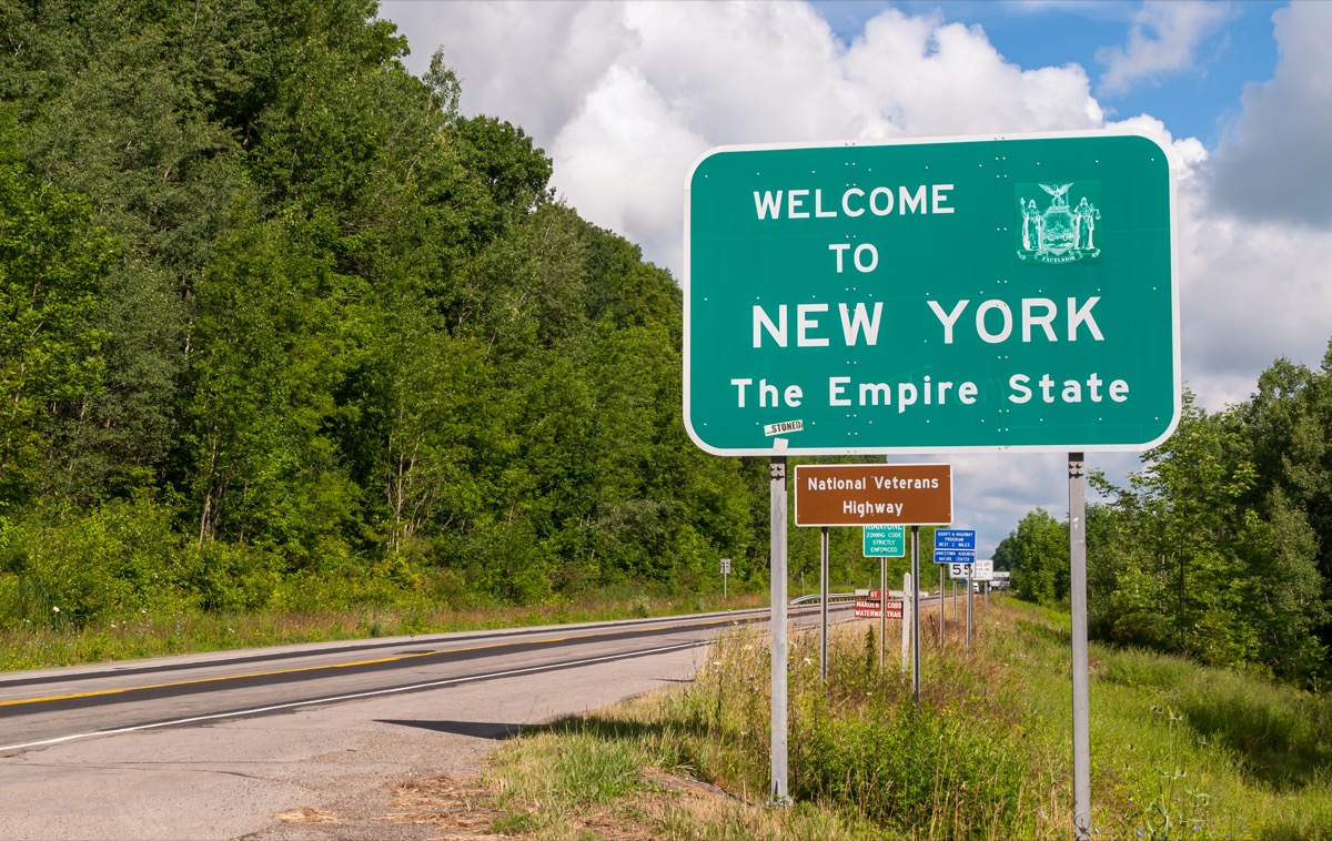 a green "Welcome to New York" sign off a highway