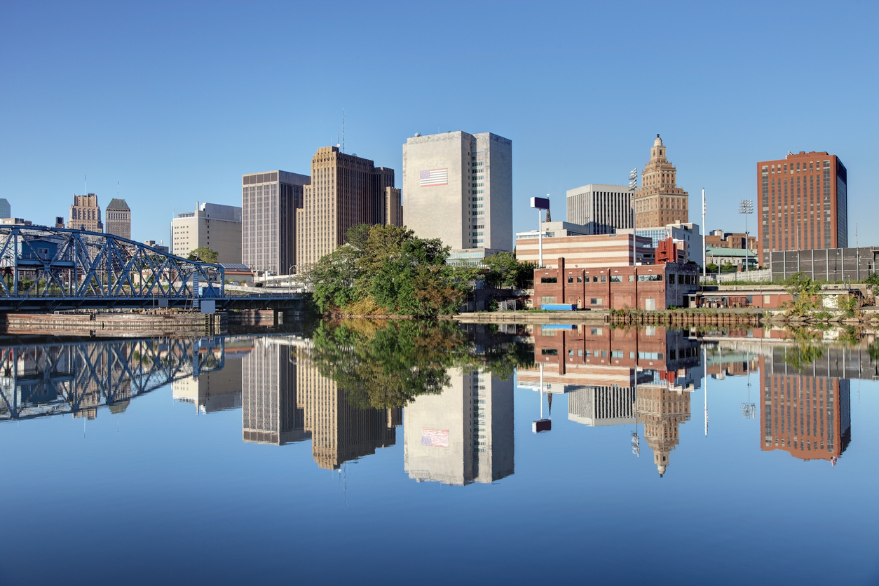 The skyline of Newark, New Jersey as shot from the Passaic River with a rail bridge on the left of the frame