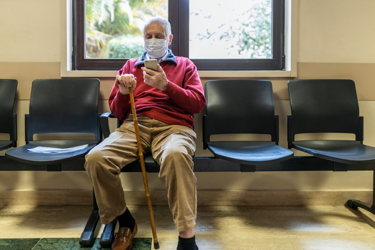 older man wearing mask in doctor's waiting room