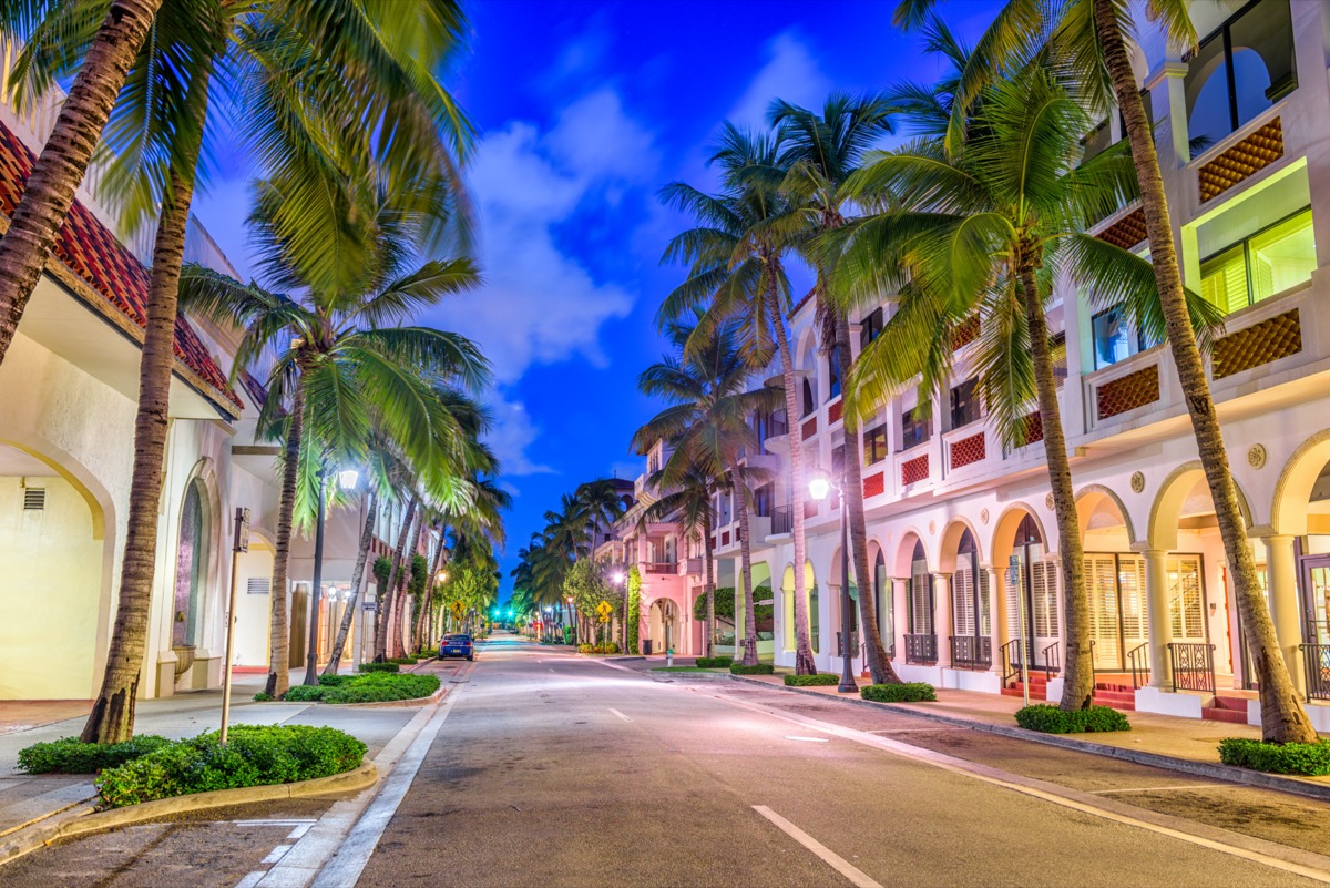 empty street, palm trees, and white buildings in Palm Beach, Florida at night