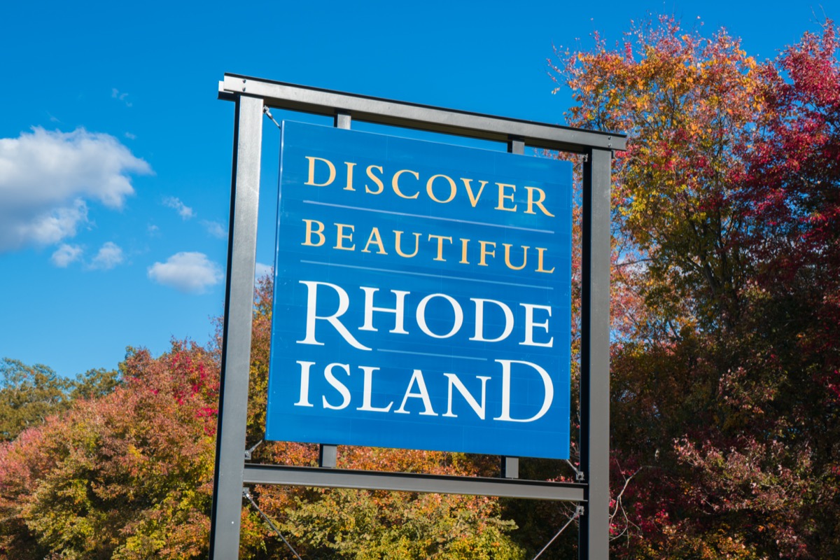 a blue "Discover Beautiful Rhode Island" sign in front of red and yellow trees