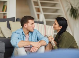 Couple sitting on the floor talking together