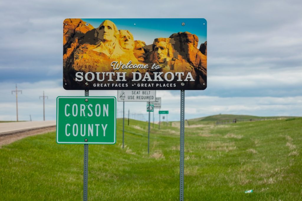 A road sign featuring Mount Rushmore and that says "Welcome to South Dakota" on it