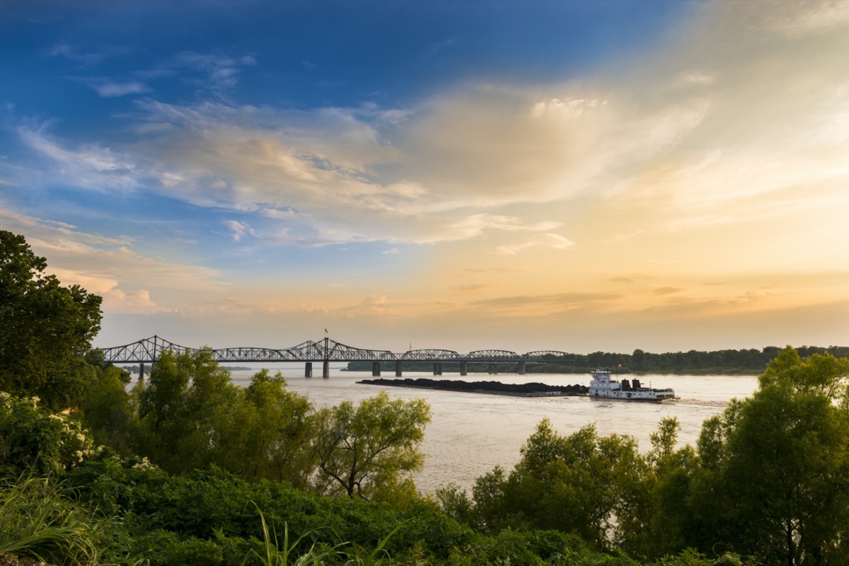 a white boat in and a bridge over the Mississippi River in Vicksburg, Mississippi