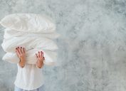 woman hold pile white pillows bedding sleeping