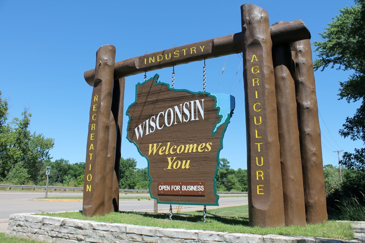 a tall and wooden "Wisconsin Welcomes You" off of a highway