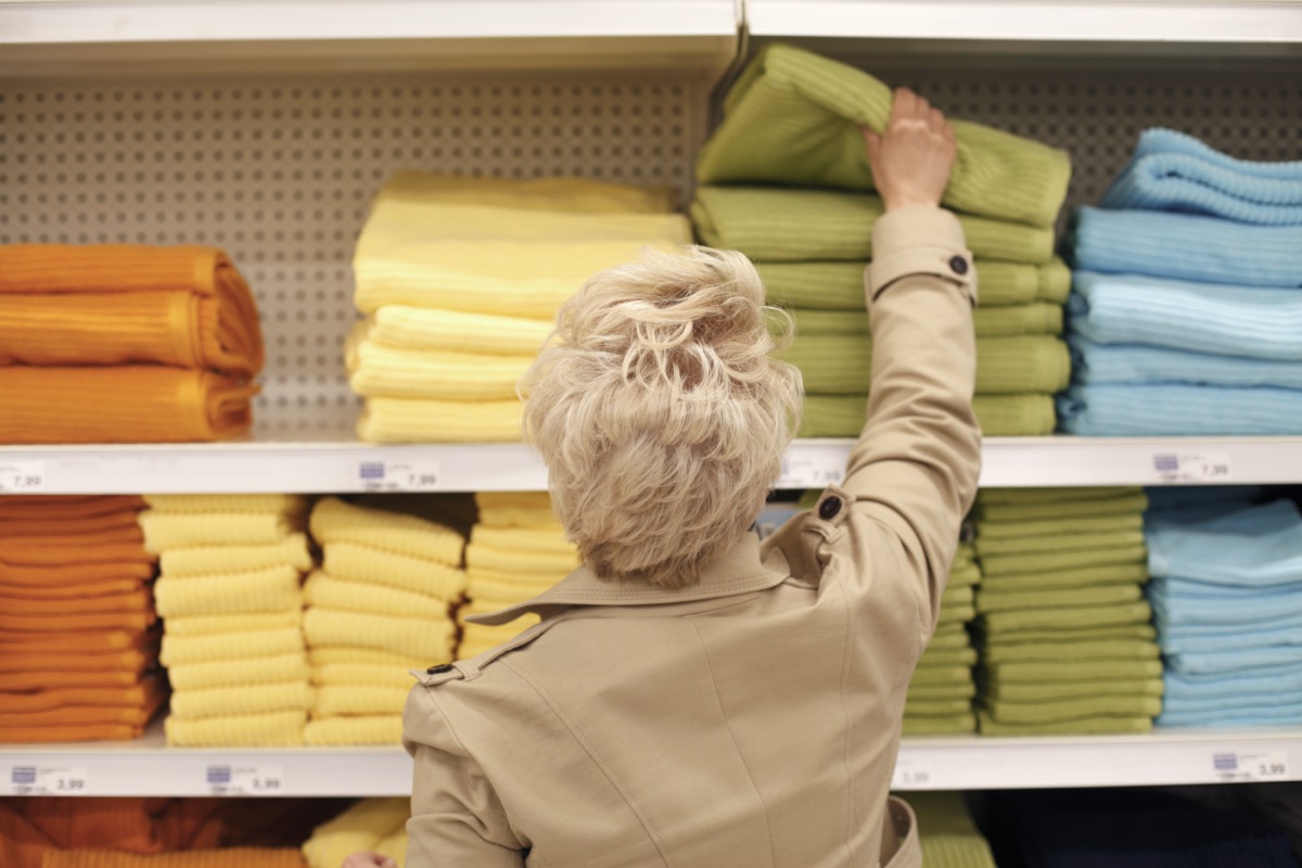 Mature woman shopping for bathroom towels.