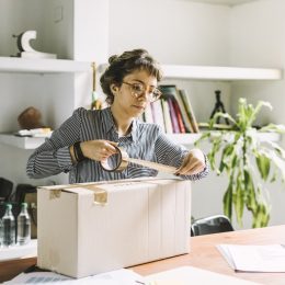 Young freelance woman sending a package to client.