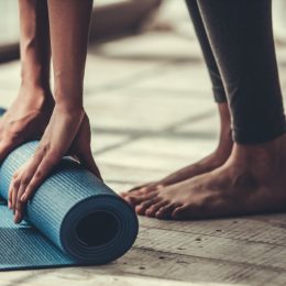 woman rolling up yoga mat