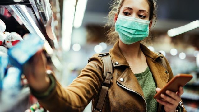 young white woman shopping wearing surgical mask