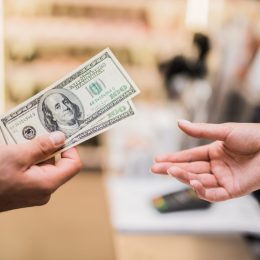 man paying with cash in store