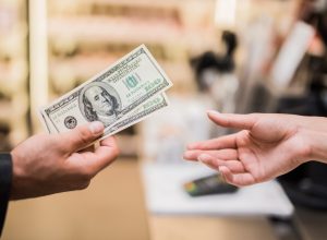 man paying with cash in store