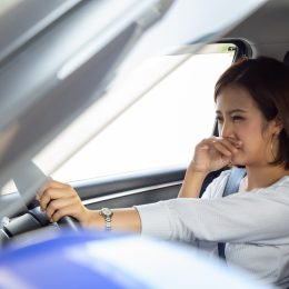 Young Asian woman hold her nose because of bad smell in car