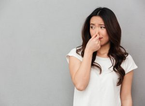 woman holding her nose from a bad smell