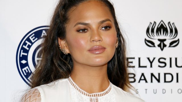 Chrissy Teigen on red carpet, discussing why she won't clap back on social media anymore