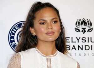Chrissy Teigen on red carpet, discussing why she won't clap back on social media anymore
