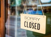 A sign reading "sorry we are closed" hangs in the window of a shop