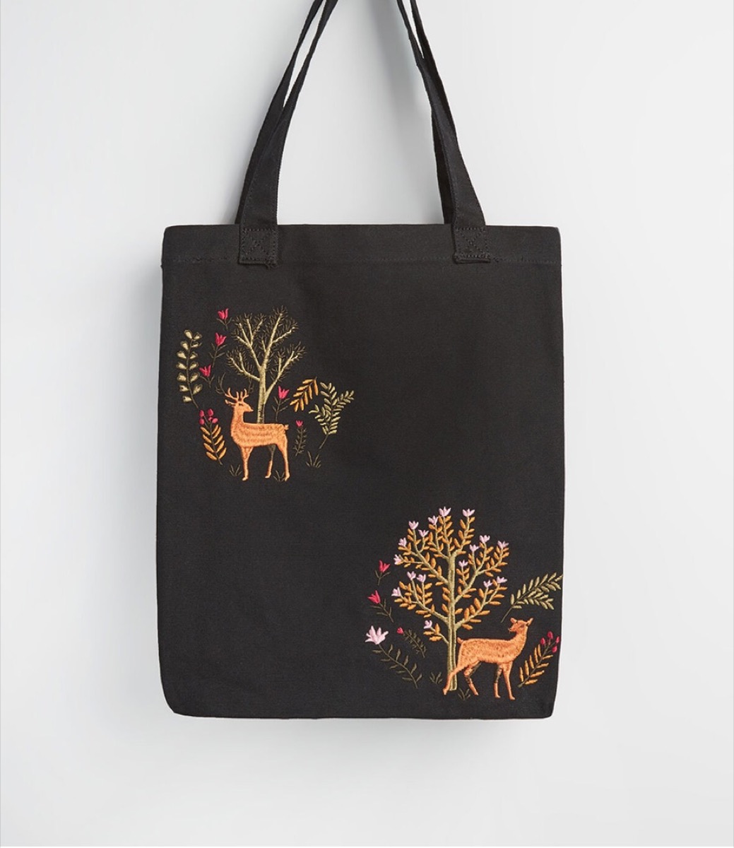 black embroidered tote with deer and trees