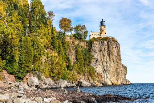 landscape photo of rocks, ocean, and lighthouse in Lake County, Minnesota