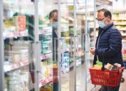 Middle age man buying food in grocery store, wearing medical mask