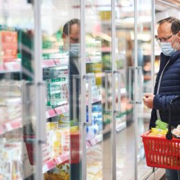 Middle age man buying food in grocery store, wearing medical mask