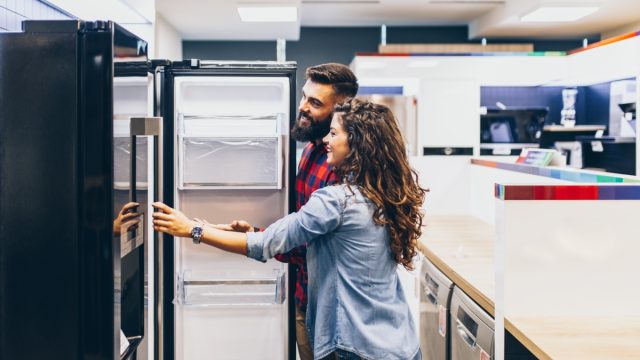 man and woman shopping for fridges