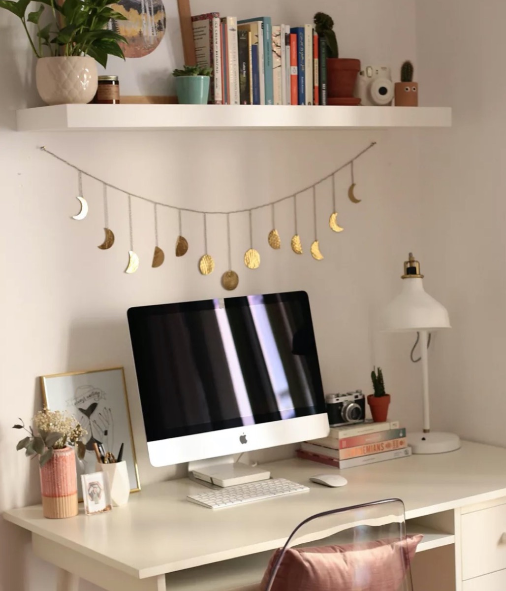 desk with gold moon phase banner hanging over it