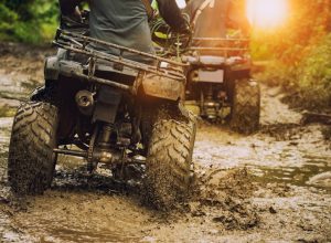 people riding atvs in mud