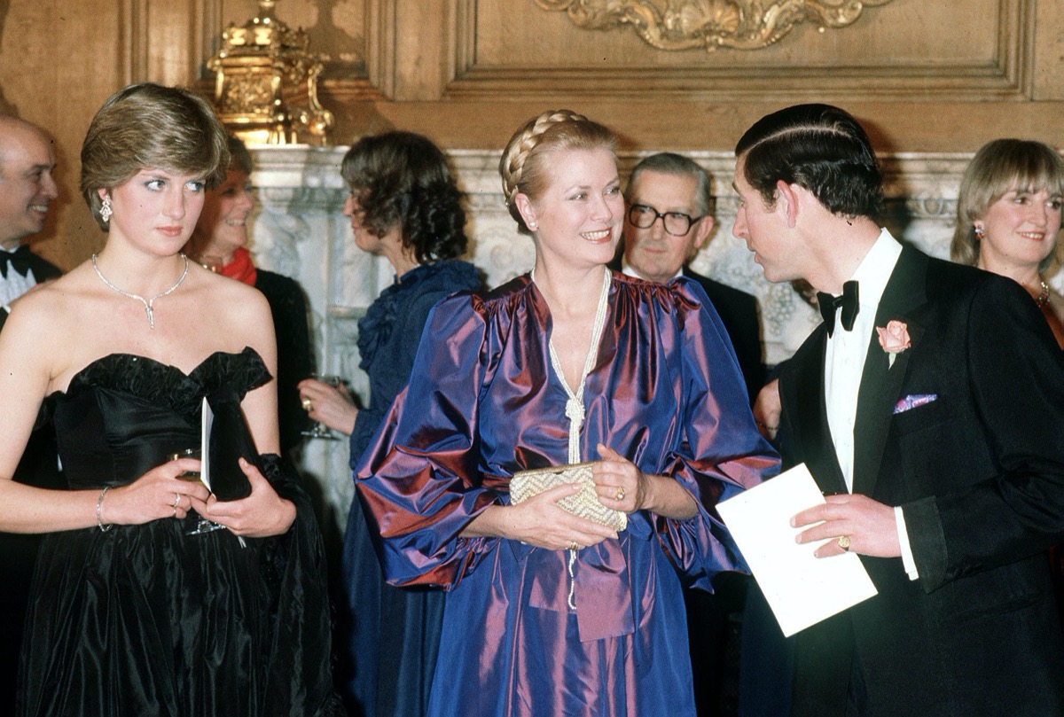 Princess Diana wearing black dress next to Prince Grace of Monaco and Prince Charles in 1982