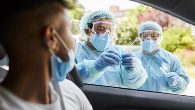 Healthcare Workers Placing Nasal Swab in Transport Medium