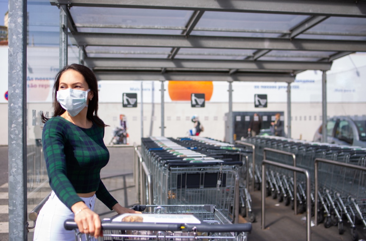 Woman with shopping cart in the supermarket parking lot during the COVID-19 pandemic in 2020
