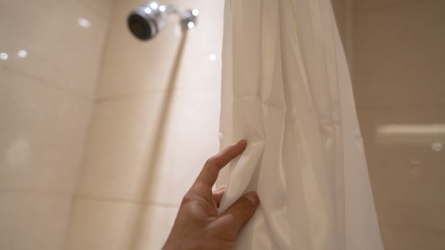 pulling bath curtain, ready to take a shower